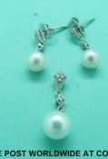 A pair of white metal earrings marked 9ct, set with a drop pearl and diamonds,
