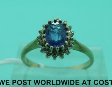 A 9ct gold ring set with an oval sapphire surrounded by diamonds (size O)