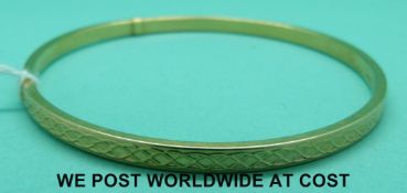 A 9ct gold bangle with cross design (3.