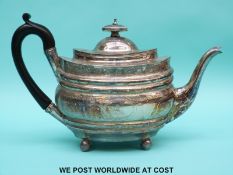 A George III hallmarked silver teapot with bright cut borders raised on ball feet,