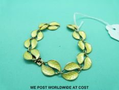 A silver bracelet by David Andersen in the form of leaves decorated with yellow enamel