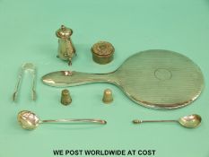 A hallmarked silver mounted hand mirror, silver pepper, trinket pot, sugar tongs,