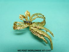 An 18ct gold brooch in the form of a stylised bow with textured finish,