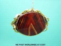 A large yellow metal brooch set with faux agate