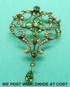 An Edwardian pendant/ brooch set with peridot and seed pearls in a floral / foliate design