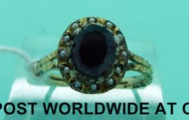 A Georgian/ Victorian ring set with an amethyst surrounded by seed pearls (size J)