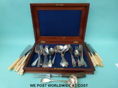 A mahogany canteen with loose cutlery and a horn handled carving fork