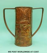 An Arts and Crafts two handled loving cup or vase, the handles riveted to the embossed body,