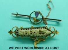 An Edwardian yellow metal brooch set with an amethyst and a yellow metal brooch set with carved