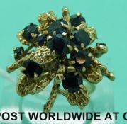 An 18ct gold ring set with round cut sapphires in a foliate design (size L)