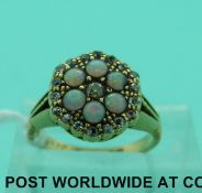 An Edwardian 18ct gold ring set with opals and diamonds in a flower cluster,