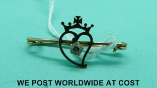 A 9ct gold brooch depicting a heart and crown set with an old cut diamond of approximately 0.