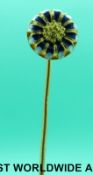 A yellow metal stick pin set with blue and white enamel in the form of a flower