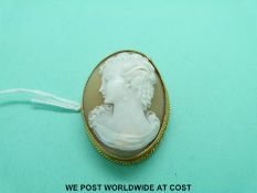 A 9ct gold brooch set with a cameo depicting a young woman