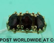 A 9ct gold ring set with three garnets (size P)