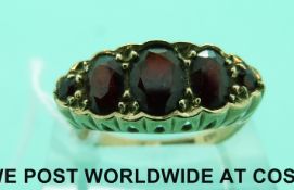 A 9ct gold ring set with graduated garnets (size O)