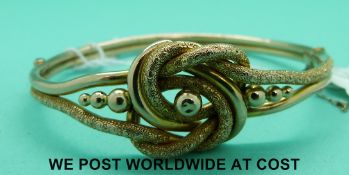 A Victorian bangle of knot design with chased decoration (9.
