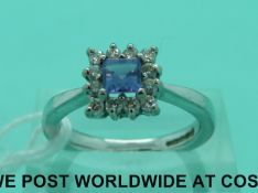 An 18ct white gold ring set with a square step cut tanzanite surrounded by diamonds (size N)