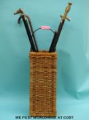 A stick basket with hallmarked silver and brass topped sticks etc.