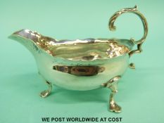 A Georgian hallmarked silver sauce boat, raised on three feet,