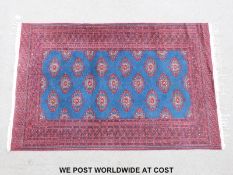 A Turkoman rug with multiple Guls on a blue central panel (190 x 123cm)