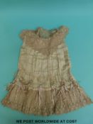 A late Victorian silk satin and lace girl's dress with satin tassels and finely made lace to the