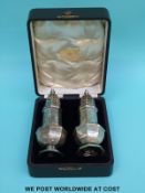 A cased pair of Edward VII hallmarked silver sugar casters,