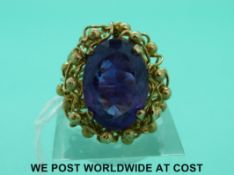 A 9ct gold ring set with large oval amethyst in an unusual bespoke setting (size K)