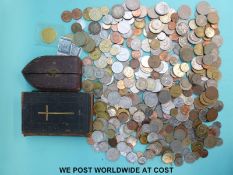 A tin of overseas coinage, crucifix etc.