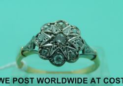 An 18ct gold ring set with nine diamonds in a platinum flower setting (size R)