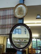 A bevelled glass oval mirror (max diameter 60cm) and a 19thC embroidery in frame