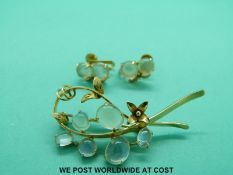 A yellow metal brooch marked 9ct set with moonstone cabochons together with matching earrings