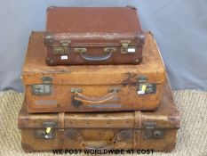 Three vintage leather suitcases.