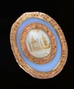 A Georgian plaque/ pendant with chased gold borders surrounding an opalised section with foiled