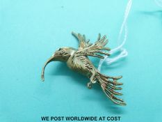 A 9ct gold brooch in the form of a humming bird with an emerald eye (6.