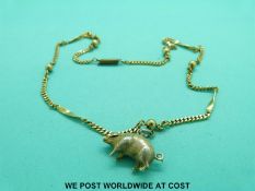 A 9ct gold charm in the form of a pig set with seed pearls and rubies on a yellow metal chain (10g)