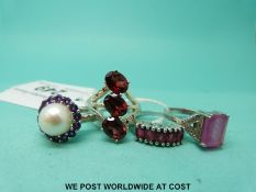 Four silver rings variously set with pink sapphire, garnets, pink diamonds, large pearl,