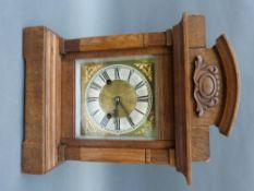 An oak cased mantel/shelf clock with silvered chapter ring on brass dial and decorative spandrels,