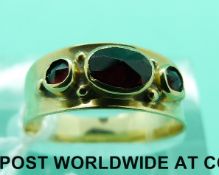 A 14ct gold ring set with three garnets (size J)