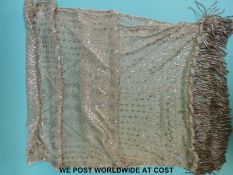 A rectangular shawl with metallic decoration and heavy fringe,