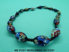A millefiori necklace made up of oval beads .