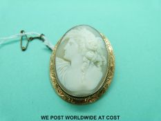 A 9ct gold brooch set with a cameo depicting a young woman