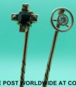 A yellow metal stick pin set with a round cut diamond and another set with a sapphire surrounded by