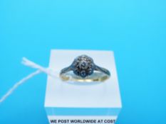 A yellow metal ring marked 18ct set with diamonds in a cluster (Size N)