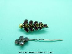 A Victorian yellow metal brooch set with garnets in a foliate design and a Victorian stick pin set