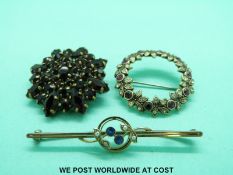 A 9ct gold brooch set with seed pearls and sapphires together with two other brooches