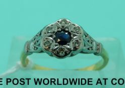 An 18ct gold ring set with a sapphire surrounded by diamonds in a flower cluster (size K)