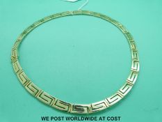 A yellow metal necklace marked 585 in Greek key design (33.