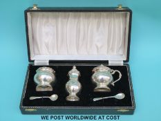 A cased hallmarked silver three piece cruet set and spoons