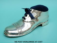 A large George V hallmarked silver pin cushion formed as a shoe with an oak sole,